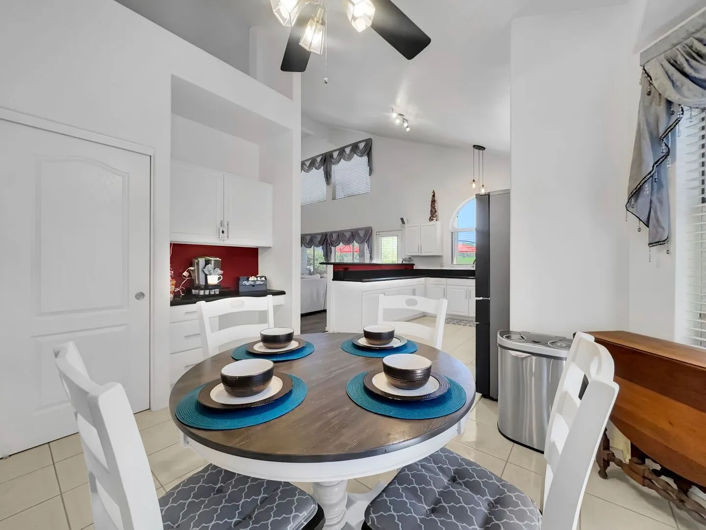Round breakfast nook table set for four beside the kitchen